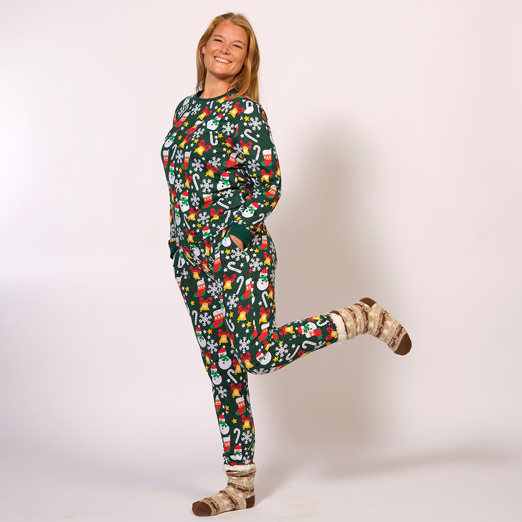 En dame poserer i en grøn julepyjamas med julemønster på.